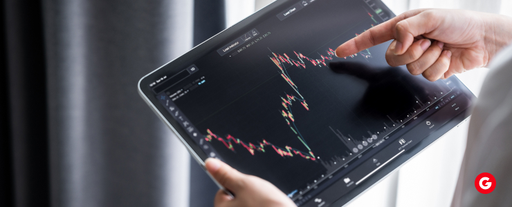 A person holding a tablet displaying a forex graph, illustrating market trends and data analysis.