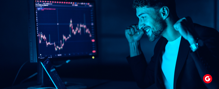 Man celebrating a successful trade while looking at a computer screen displaying an MT4 forex chart, symbolizing MT4 copy trading success